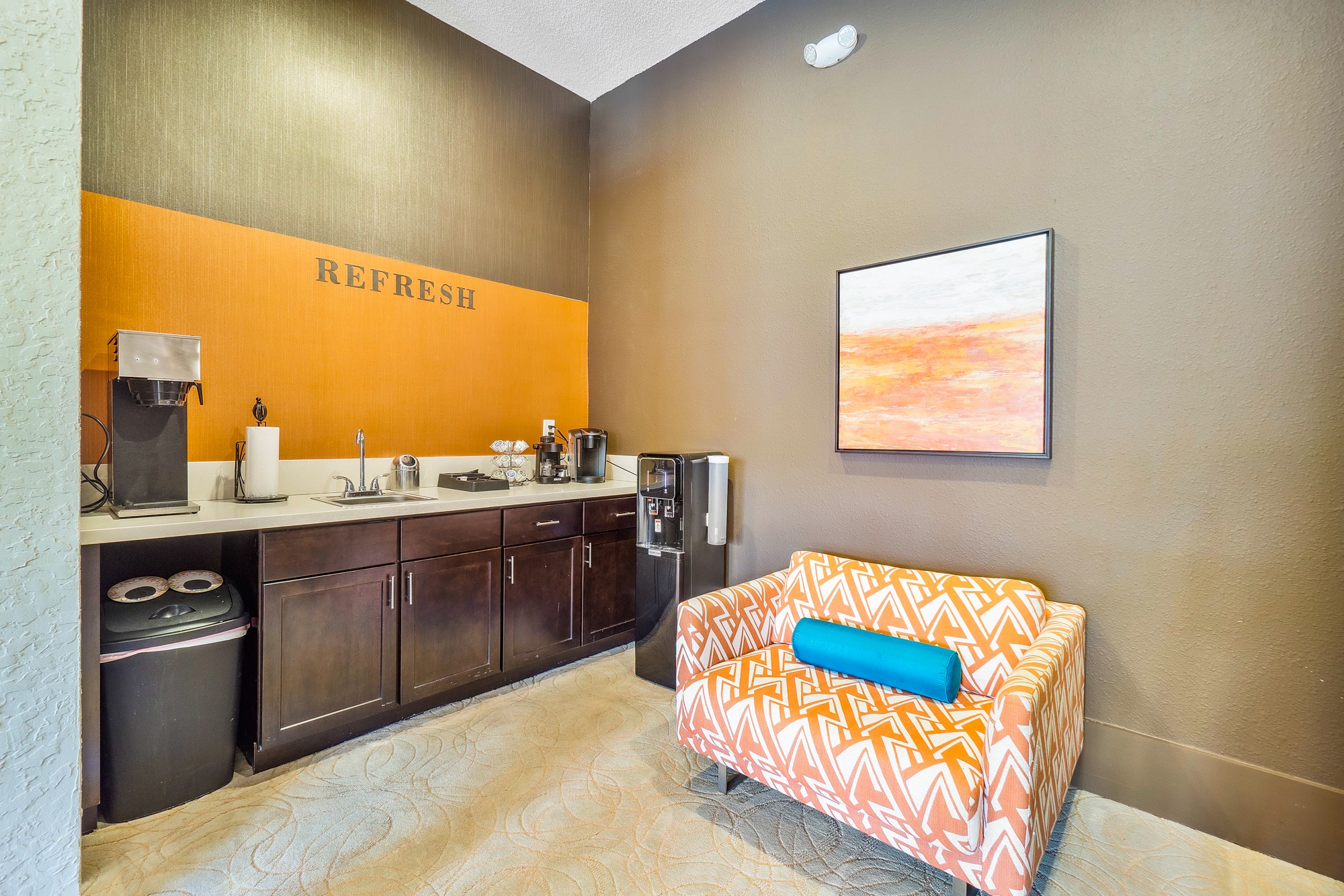 A room with a couch and a fridge.